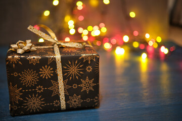 Christmas gift box on a blue surface with a blurred background
