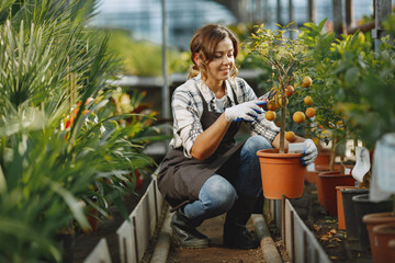 Fototapeta na wymiar Woman in a apron working in a greenhouse