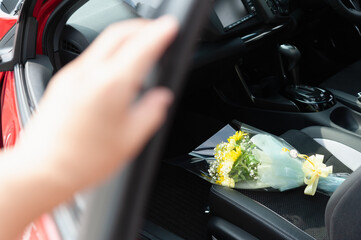 車の助手席に置かれた花束とドアに置かれた手