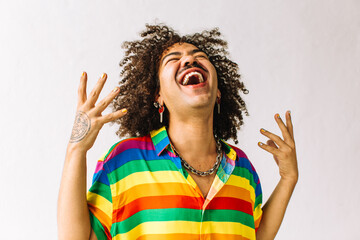 Happy young gay man cheering in a studio