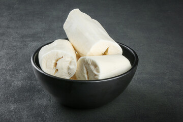 Cassava pieces isolated on dark background.