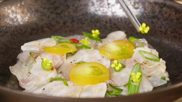 Decorating Peruvian ceviche close-up. Fresh cooked ceviche made of raw white fish. Traditional Peruvian cuisine. Cooking seafood dish.