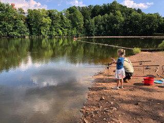 Fototapeta na wymiar Young girl and her grandpa fishing 