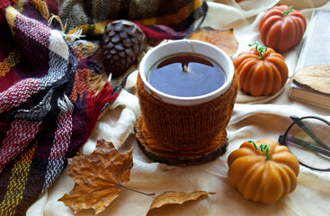 Cozy autumn mood. Coffee or tea and decor, pumpkin-shaped candles. Winter or autumn concept, warm home scene. 