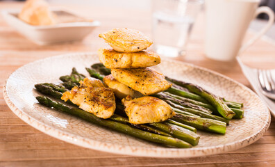cooked dish. Chicken nuggets with green asparagus on plate