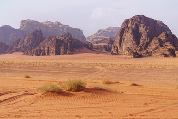 Wadi Rum desert, Jordan. The Valley of the Moon. Red sand, mountains and haze. Designation as a UNESCO World Heritage Site. National park outdoors landscape. Offroad adventures travel background.