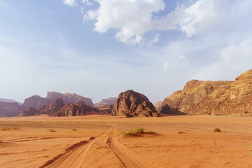 Fototapeta na wymiar Wadi Rum desert, Jordan. The Valley of the Moon. Red sand, mountains and haze. Designation as a UNESCO World Heritage Site. National park outdoors landscape. Offroad adventures travel background.