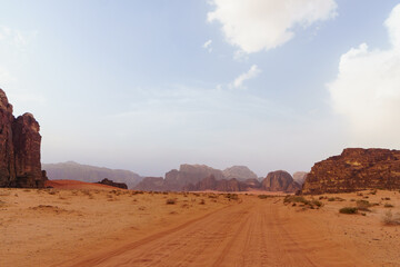 Fototapeta na wymiar Wadi Rum desert, Jordan. The Valley of the Moon. Red sand, mountains and haze. Designation as a UNESCO World Heritage Site. National park outdoors landscape. Offroad adventures travel background.
