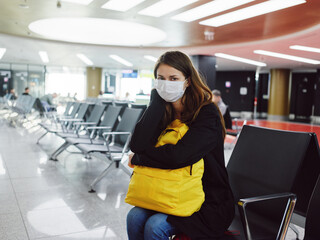 woman in medical mask with luggage airport waiting flight delay