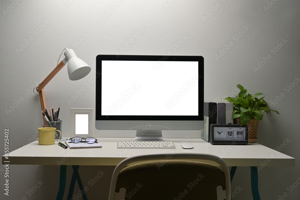 Poster mock up with computer with a white blank screen display and putting on a working desk surrounded by 
