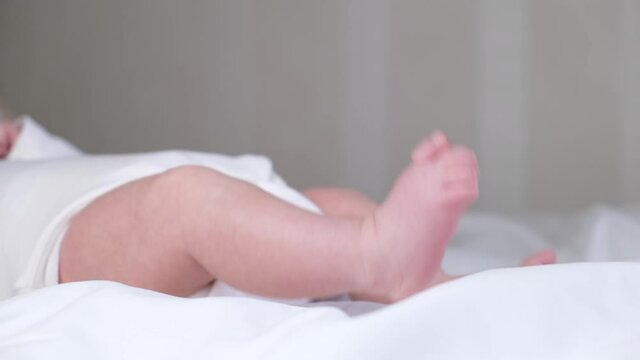 Tiny baby feet . Newborn baby lying in in child crib. Childhood concept