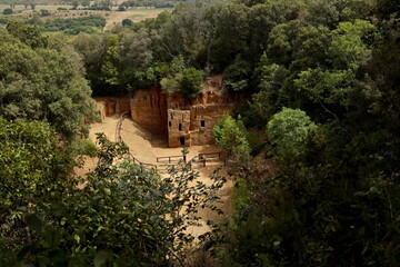 The Etruscan Necropolis of the Populonia Caves emerges among the vegetation. Archaeological Park of Baratti and Populonia. Tuscany - Italy - obrazy, fototapety, plakaty