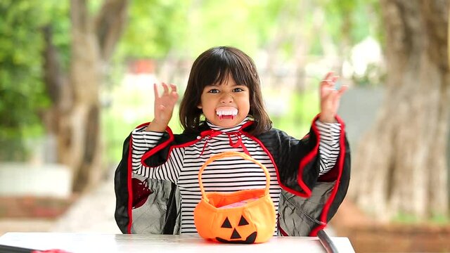 Halloween, holiday and childhood concept. Little kids southeast asian on halloween dressed in a witch costume. funny kids in carnival costumes outdoors.
