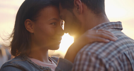 Closeup of multiracial young couple in love hug and touch foreheads on street in evening