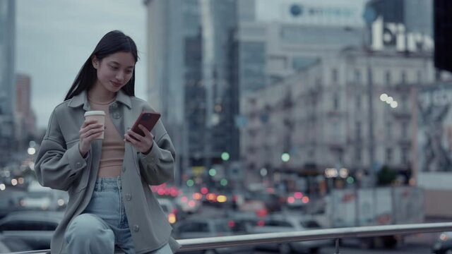 Attractive asian woman using cell phone on street