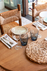 Mesa de restaurante turístico en la playa con copas, vasos, platos y cubertería completa