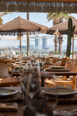 Mesa de restaurante turístico en la playa con copas, vasos, platos y cubertería completa