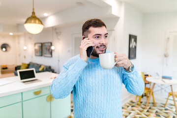 person drinking coffee hand of mobile .handsome man drinking coffee in home