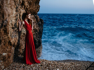 woman in red dress on the beach ocean posing luxury romance