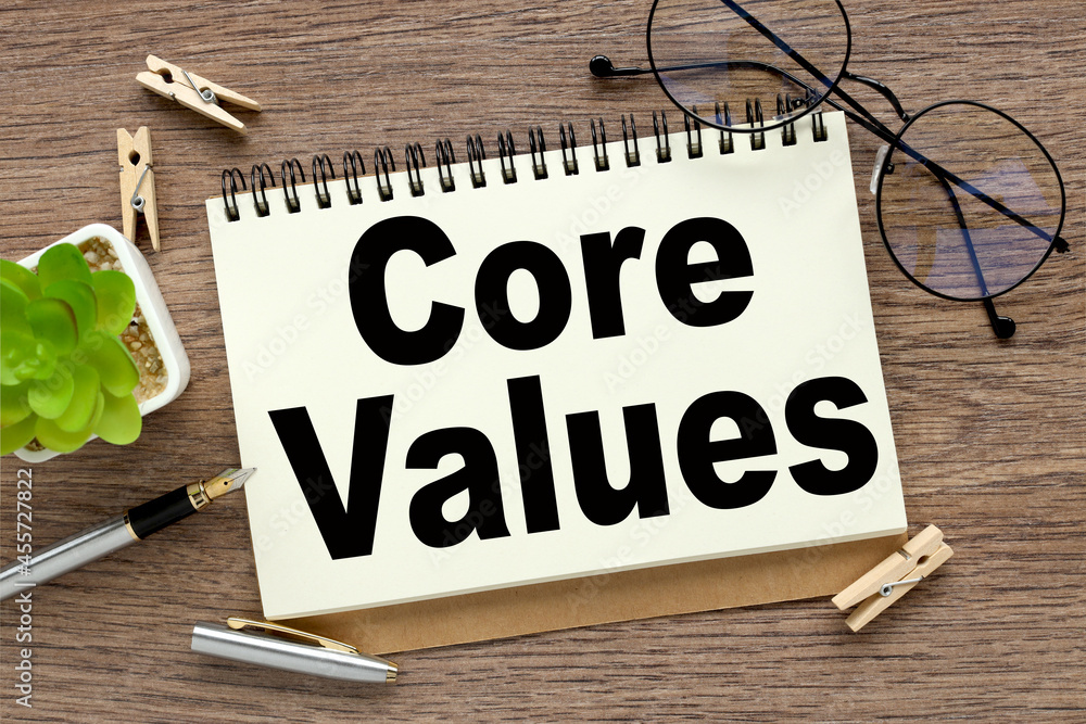 Poster core values - text on white notepad paper on wood background