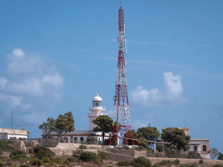Obraz premium Marine lighthouse and telecommunication tower in a coastal area.