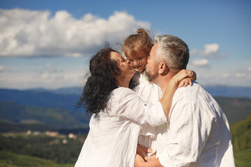Fototapeta premium Grandparents in summer mountains with granddaughter