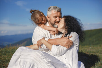 Fototapeta premium Grandparents in summer mountains with granddaughter