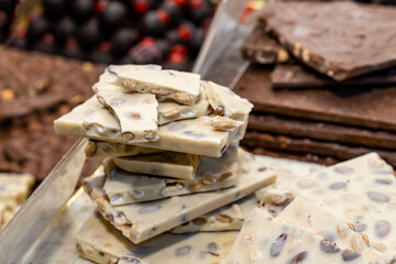 Fototapeta na wymiar white chocolate with nuts stack on dark background selective focus