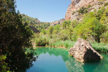 Calm lake in mountains with green forest around Spain. Nature card.