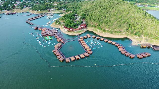 Wooden raft resort floating on dam with mountain