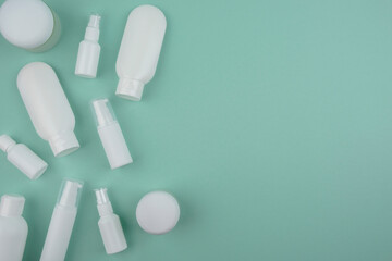 Plastic white tubes for cream or lotion bottles different sizes. Top view on light mint green...