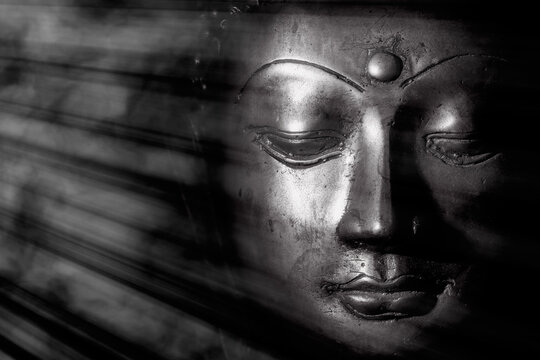 Mindful monochrome buddha face with mystical heavenly light. Spritual enlightenment.