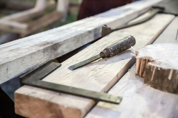 iron angle ruler and chisel on wooden planks construction tools selective focus
