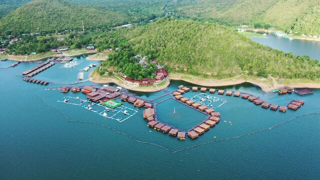 Wooden raft resort floating on dam with mountain