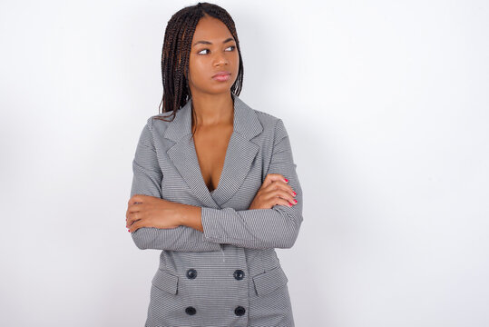 Image of upset Young african american business woman with braids over white wall with arms crossed. Looking with disappointed expression aside after listening to bad news.
