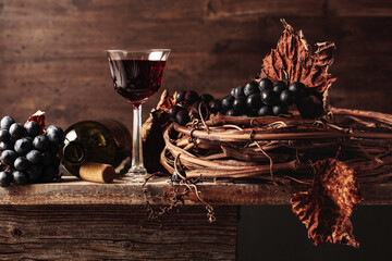 Red wine with grapes on an old wooden table.