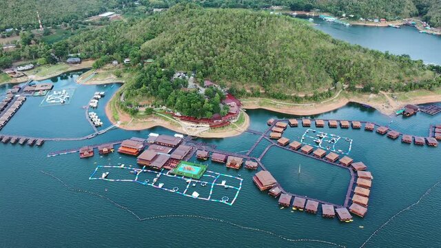 Wooden raft resort floating on dam with mountain