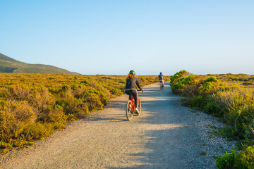Obraz premium Young couple cycling on rural road in Montana de Oro State Park, Los Osos, California Central Coast