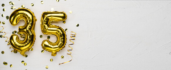 golden foil balloon number thirty five. Birthday or anniversary card with the inscription 35. gray concrete background. - obrazy, fototapety, plakaty