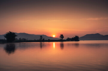 Sunrise over mountain range on Lam Taphoen reservoir in countryside
