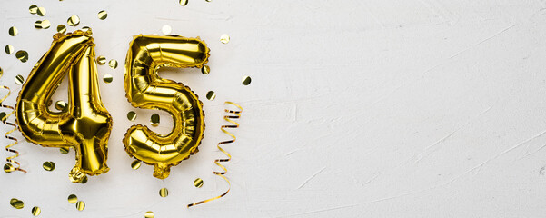golden foil balloon number forty five. Birthday or anniversary card with the inscription 45. gray concrete background. - obrazy, fototapety, plakaty