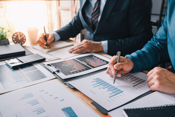 Business Consulting meeting working, two business people talking, brainstorming to making a profit of company planning to analyze investment and marketing business strategy projection table in office.