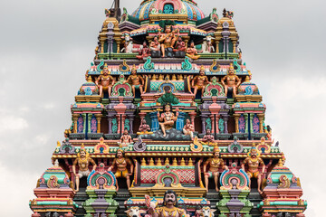 A colorfully decorated tower with mythological figures and deities in an ancient Hindu temple in Tamil Nadu.