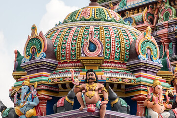 Fototapeta premium A colorfully decorated tower with mythological figures and deities in an ancient Hindu temple in Tamil Nadu.