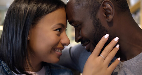 Closeup loving mixed race couple embracing and smiling