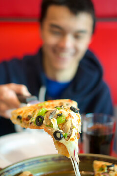 Blurred man holding pizza slice