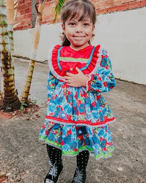 Girl in blue floral dress standing outdoor