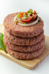 Raw beef burgers blended with caramelised red onion and tangy red Leicester cheese prepared for grilling