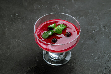 Panna cotta with berry sauce on black stone table