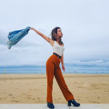 Woman in orange pants posing on the beach